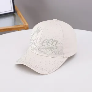 Dettaglio degli strass olografici Queen e corona su questo berretto da baseball beige