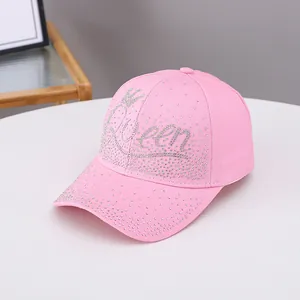 Dettaglio del cappellino da baseball rosa con strass scintillanti motivo Queen e corona