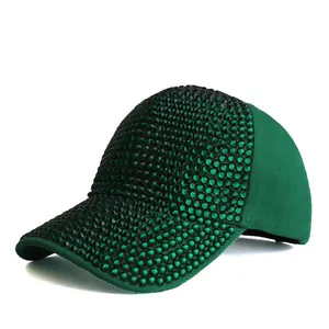 Dettaglio laterale del cappello verde con strass scintillanti e decorazioni di perline