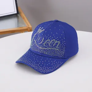 Dettaglio del cappello da baseball blu reale con corona di strass e scritta 'Queen'