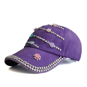 Close-up of purple baseball cap with silver metal studs and colorful resin flower details