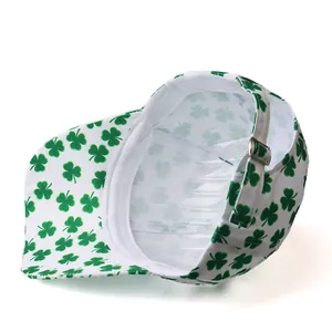 Detail view of the green shamrock pattern and adjustable metal buckle on white baseball cap