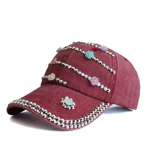 Detail of burgundy washed denim baseball cap with silver rivets and floral embellishments