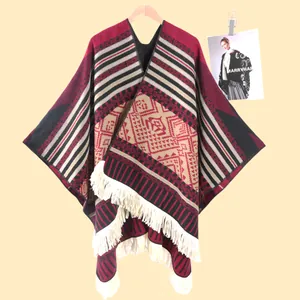 Detaillierte geometrische Muster und weiße Fransenquasten an einem Reise-Cape im Ethno-Stil