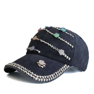 Detail of washed cotton baseball cap with silver studs and colorful resin flowers