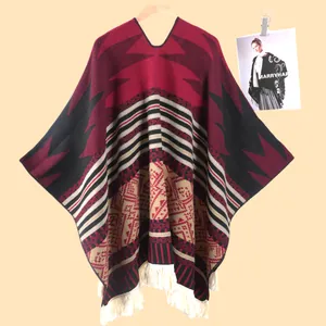 Detail von geometrischem Strickmuster und dichten weißen Fransen am roten Herrenponcho