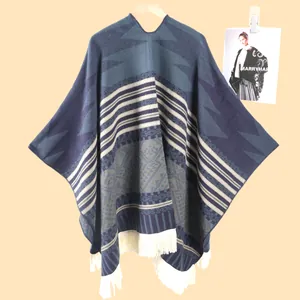 Detailansicht der geometrischen Muster und weißen Fransen an diesem blauen West-Poncho