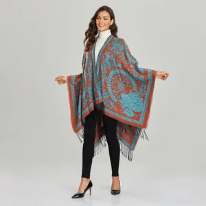 Close-up of retro paisley knit shawl featuring orange ethnic patterns and long black fringe