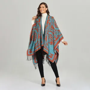 Detail of bohemian paisley shawl featuring bright orange blue patterns and black tassels