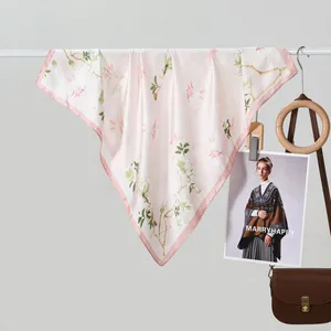 Elegant floral silk scarf in pale pink hanging with stylish fashion accessories