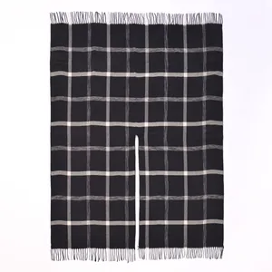 Detail view of British plaid shawl wrap with fine tassel trim and poncho style slit