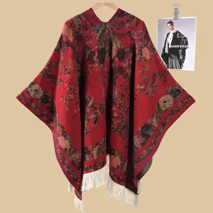 Details eines Vintage-Strickponchos mit Blumenmuster und cremefarbenen Fransen