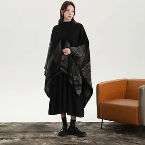 Détail d'un poncho en maille élégant avec motif de paysage vintage et ourlet à franges