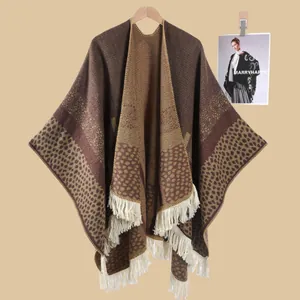 Detail eines braunen Strickponchos im Vintage-Stil mit Quasten und Leopardenmuster-Stoff