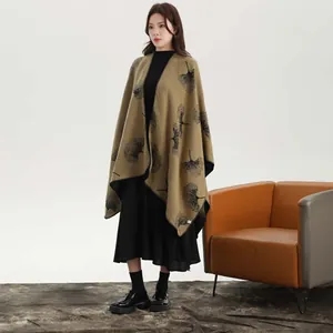 Detail of camel knitted poncho showing black ginkgo leaf patterns and hem craftsmanship