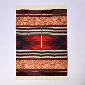 Détail d'un poncho ethnique avec motifs jacquard rouge et noir et des franges blanches