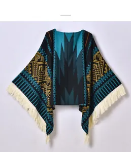Close-up of ethnic knit poncho featuring Aztec geometric patterns and long tassel fringe