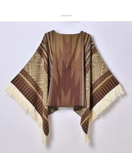 Detailed view of bohemian knitted poncho with ethnic geometric patterns and cream fringe