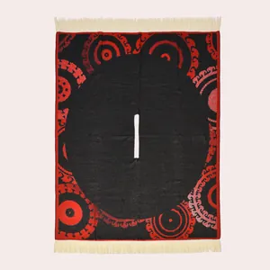 Close-up of ethnic red and black jacquard knit poncho with cream fringe detail