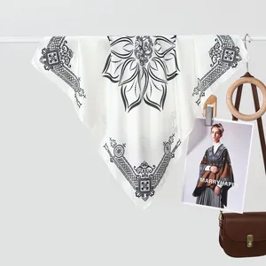 Detail van een crèmekleurige zijden sjaal met zwarte mandala-print aan een stang