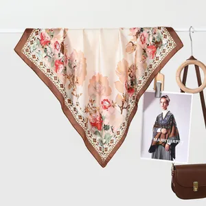 Detail van zijden vierkante sjaal met rode bloemmotieven en elegante donkerbruine rand