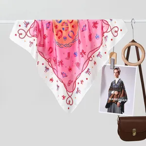 Detail van roze zijden sjaal met sterren- en hoefijzerpatronen op een leren tas