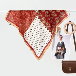Elegant silk scarf with paisley and polka dot print hanging on a minimalist bar