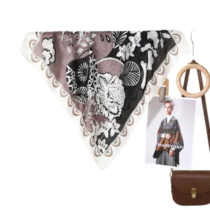 Elegant floral print silk scarf in brown and beige colors hanging with fashion accessories
