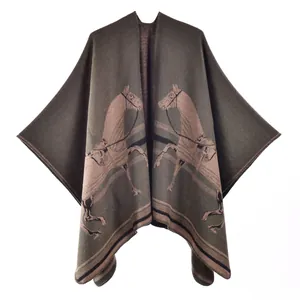 Close-up of olive green cashmere-style knitted poncho with symmetric horse motifs