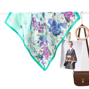 Elegant mint green silk scarf with floral botanical prints and insects hanging for display