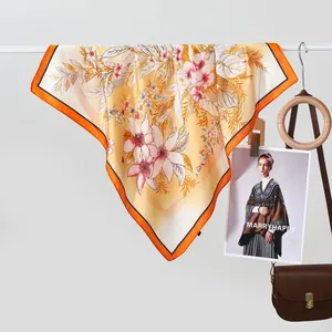 Elegant yellow floral silk scarf for women featuring premium satin drape and orange border