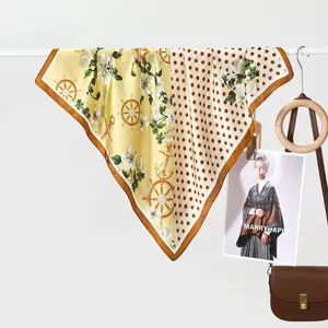 Classic polka dot and floral silk scarf hanging on a white rack with vintage leather bag