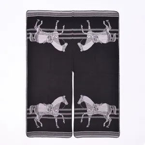 Detailed view of the black horse pattern shawl with white knit motifs and stitched edges