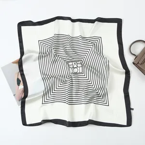 Flat lay of square silk scarf with black and white geometric lines and fashion props