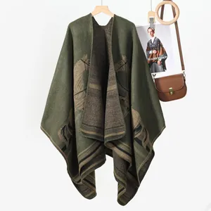 Detail of knit shawl featuring horse jacquard pattern and textured dark green fabric