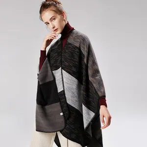 Detailopname van oversized gebreide sjaal met kleurblokstrepen en precieze stikselranden
