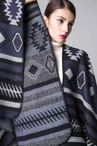 Gros plan détaillé sur un poncho en tricot à motifs géométriques et finitions de haute qualité