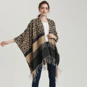 Detailed macro view of leopard print knit fabric and tassel hem on winter poncho