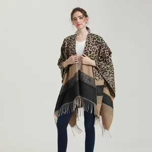 Detail view of leopard print knit poncho with fringe edges and color block pattern