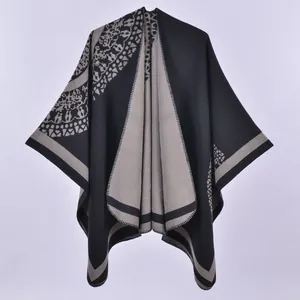 Detailed view of black and grey knit shawl with geometric patterns and fringe