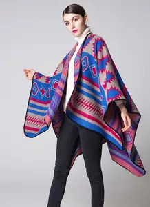 Détail du poncho en maille géométrique montrant des motifs colorés et un tissu chaud