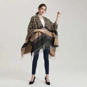 Detail of cashmere-like poncho featuring leopard print with color-block stripes and fringe