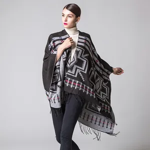 Detail of ethnic geometric knit shawl with fringe trim and thick cashmere-like texture