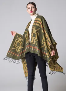 Close-up of ethnic geometric pattern and black fringe on green knit cashmere-like poncho