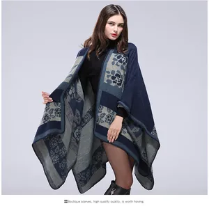 Detailed knit texture and floral pattern of a navy blue Aztec style shawl cape