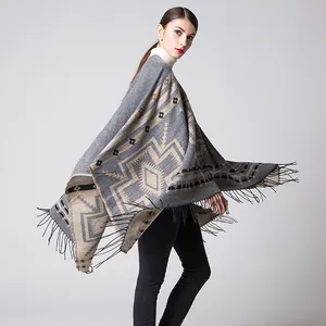 Detail of bohemian geometric pattern shawl with long black tassels and soft knit texture