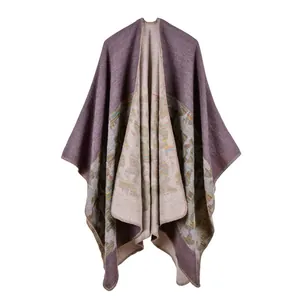 Detail view of purple and beige knitted poncho featuring geometric ethnic patterns