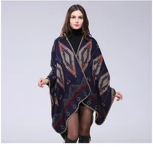 Detailed view of Aztec style thick knitted poncho featuring neat stitched edge and geometric pattern