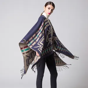 Detail of bohemian knitted poncho featuring ethnic patterns and fringe tassels hemline