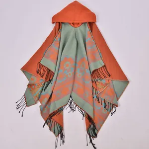 Close-up of bohemian hooded shawl with vibrant floral patterns and black fringe tassels